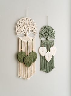 two wall hangings with heart shaped leaves and tree of life decorations on the wall