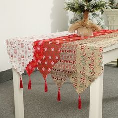 a table with a red and white cloth on it next to a potted plant