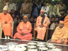 some people are sitting in chairs and one is wearing an orange outfit