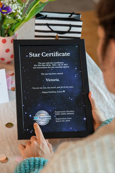 a woman is holding up a star certificate