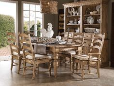 a dining room table with chairs and a rooster statue