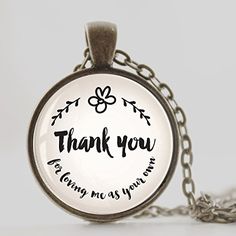 a glass pendant with the words thank you and an image of a flower on it