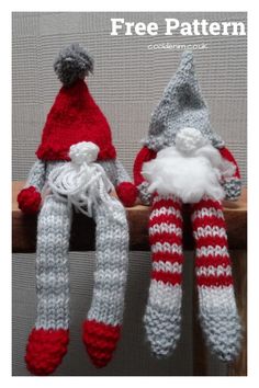 two knitted gnomes sitting next to each other on a wooden rail with white and red stripes