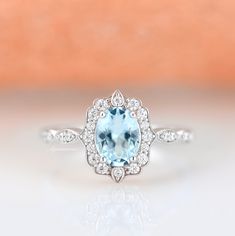 Gorgeous vintage inspired aquamarine ring is made of 925 solid sterling silver, making a simple but elegant statement piece. This ring is perfect to wear as engagement ring, promise ring, birthstone ring, or statement ring. Hypoallergenic, lightweight and minimalist. Main Stone: Aquamarine Shape: Oval Gem size: 6 x 8 mm Carat Weight: 1.4 ct. (approx.) Stone Creation: Lab-Created Hardness: 8 (Mohs scale) ►Your sterling silver ring will not turn green itself and will not cause your skin to turn gr Classic Crystal Birthstone Ring For Anniversary, Classic Birthstone Crystal Ring For Anniversary, Classic Topaz Ring With Diamond Accents For Anniversary, Vintage Gemstone Halo Ring For Anniversary, Vintage Halo Ring With Center Stone As Gift, Vintage Halo Ring With Center Stone For Gift, Vintage Wedding Birthstone Ring With Halo Setting, Vintage Birthstone Wedding Rings, Vintage Wedding Rings With Birthstone