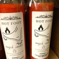 two bottles of hot foot magic candle sit on a shelf next to eachother