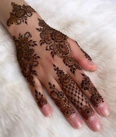 a woman's hand with henna tattoos on it