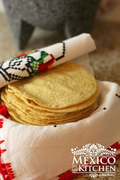 mexican tortillas are stacked on top of each other in a bowl with a napkin