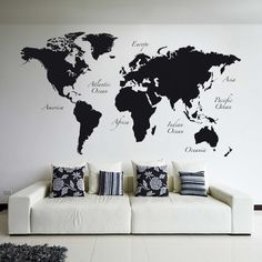 a living room with a white couch and a black world map on the wall