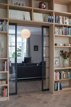 a living room with bookshelves filled with lots of books and a couch in the corner