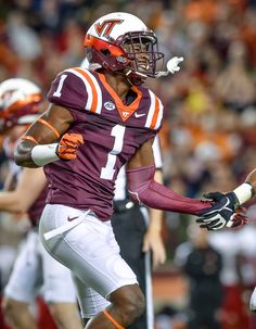 a football player running with the ball in his hand and other players on the field behind him