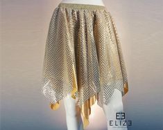 a white mannequin wearing a gold skirt with sequins on the bottom