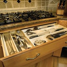 an open drawer in a kitchen filled with utensils