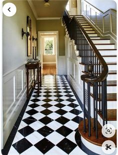 a black and white checkered floor in a house with stairs leading up to the second floor