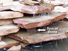 a stack of rocks with water running down them and an arrow pointing to spacer stone