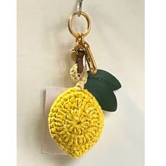 a keychain with a yellow flower and green leaf on it's side