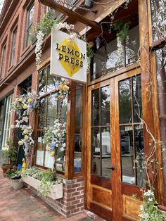 the front entrance to lemon press with flowers hanging from it's windows and an awning