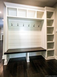 an empty bench in the middle of a room with built - in bookshelves