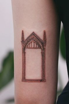 a woman's arm with a tattoo on it that has an image of a building