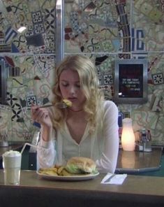 a woman sitting at a table eating food