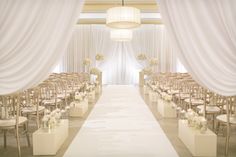 the aisle is lined with chairs and white drapes