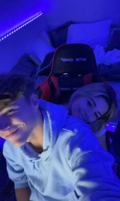 two people are laying in bed and smiling at the camera