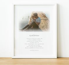 a white framed photo with the words godmoter and a couple sitting on a dock