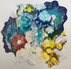 an art work made with paper and other items on a white surface, including fan shaped objects