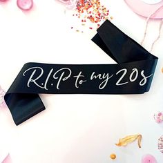 a black ribbon with the words ripty my 205 on it, surrounded by confetti and sprinkles