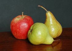 two pears and an apple on a table