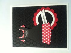 a black card with red and white polka dots on it, featuring an image of a woman's dress