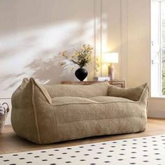 a living room with a large bean bag chair in front of a window and a rug on the floor