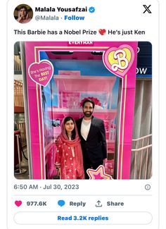 two people standing in front of a pink barbie doll house with the words barbie on it