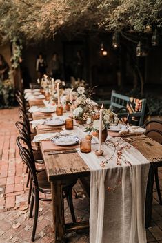 an outdoor dining table set with place settings