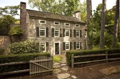 an old stone house surrounded by trees and bushes