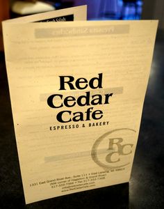 a red cedar cafe menu sitting on top of a counter