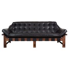 a black leather couch with wooden legs