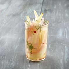 a glass filled with food sitting on top of a wooden table