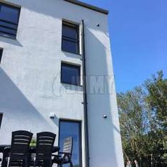 three black chairs sitting in front of a white building