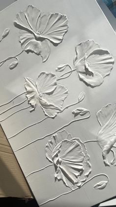 some white paper with flowers and leaves on it