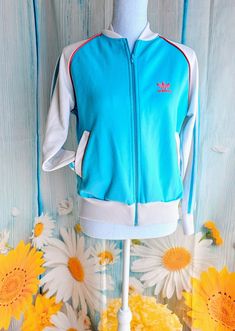 Wonderful retro track jacket by Adidas Label states size Medium - please compare to your measurements it my fit more like a modern small Measurements are taken with garment laying down flat: Underarm to underarm 21" Length from middle of neck down 22.5 87% Polyester 13% Cotton 90s Style Blue Track Jacket For Fall, Blue Retro Track Jacket For Spring, Blue Fitted Casual Track Jacket, Vintage Blue Long Sleeve Track Jacket, Blue Sports Track Jacket With Zipper Closure, Blue Sporty Track Jacket With Zipper, Fitted Blue Track Jacket For Streetwear, Fitted Blue Track Jacket For Spring, Blue Retro Track Jacket For Sports