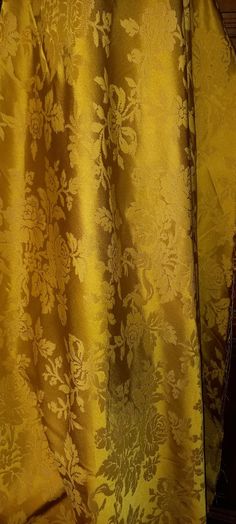 a yellow and brown curtain with flowers on it