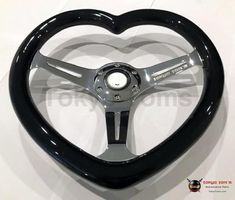 a heart shaped steering wheel with black spokes