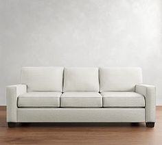 a white couch sitting on top of a hard wood floor