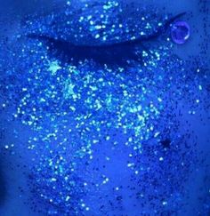 a man's face covered in blue glitter