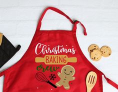 a red apron that says christmas baking crew next to some cookies and utensils