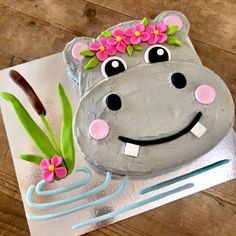 a cake shaped like a hippo with flowers on it