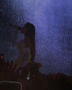 a woman standing in the rain holding an umbrella