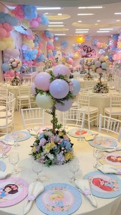 a table set up for a princess themed birthday party with balloons and flowers on it