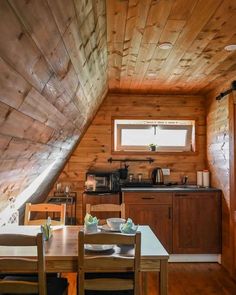 a kitchen and dining area in a small cabin with wood paneling on the walls