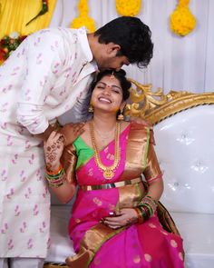 a man kissing a woman on the cheek in front of a decorated stage with flowers